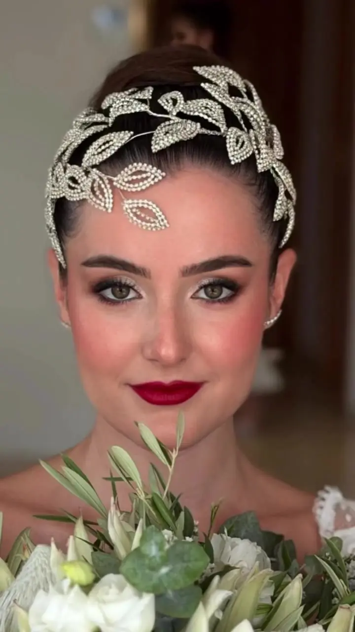 Novia con tocado de hojas plateadas y labios rojos