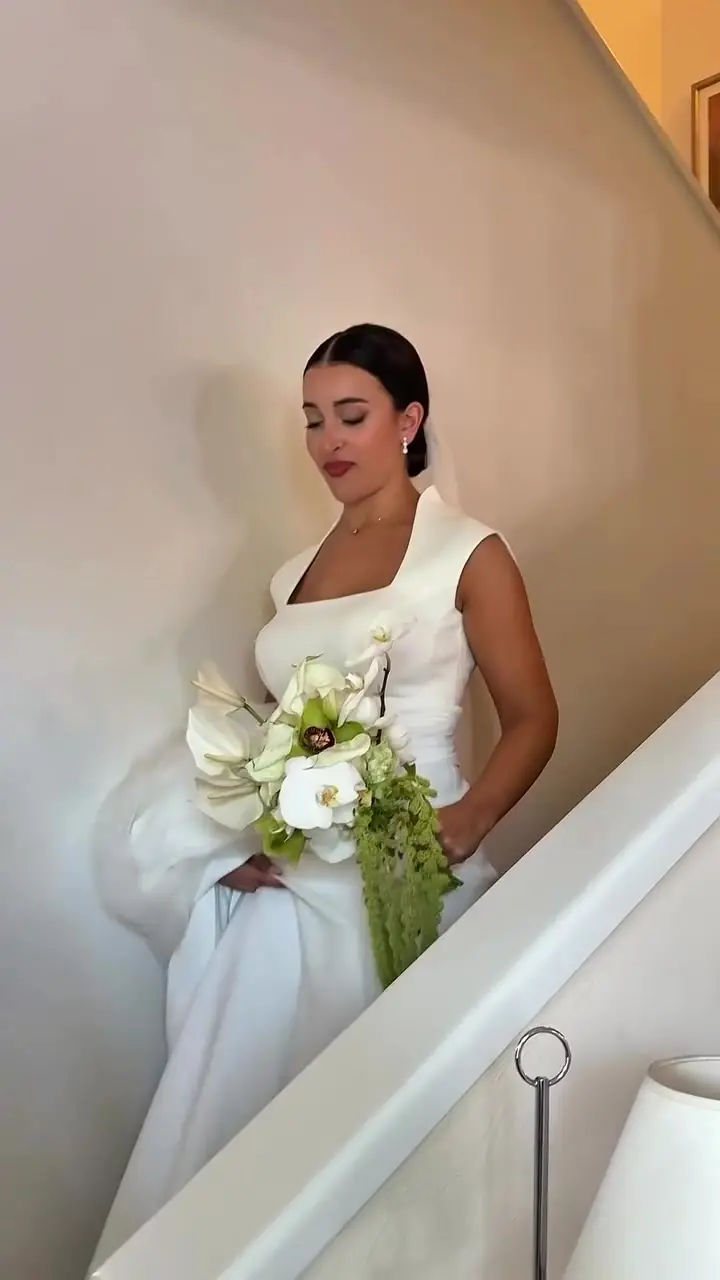 Novia con ramo de calas, en la escalera de su casa